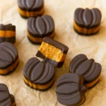 Chocolate Pumpkin Butter Cups with creamy pumpkin spice filling on parchment