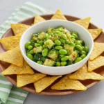 Spicy cucumber edamame salad served in a bowl with tortilla chips