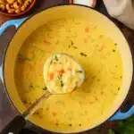 carrot potato soup in a bowl with parsley garnish