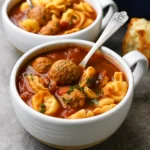 Meatball Tortellini Soup in a Dutch oven with cheese and herbs