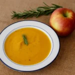 Butternut Squash & Apple Soup with Rosemary served in rustic bowl
