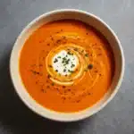 Butternut Squash Bisque Recipe served in a bowl with cream swirl