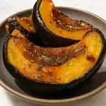 roasted acorn squash with honey butter on baking sheet