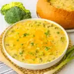 Bowl of Slow Cooker Panera Broccoli Cheddar Soup with melted cheddar and scallions.