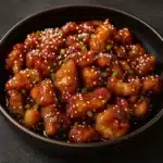 Honey Sesame Chicken in skillet with sesame seeds and green onions
