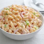 Pink Cadillac Pasta Salad in white bowl with creamy dressing and vegetables
