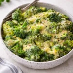 A bowl of fresh steamed cheesy broccoli with creamy cheddar sauce