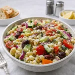 Chopped Greek Pasta Salad in a white bowl on a wooden table