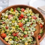 A vibrant bowl of Cilantro Lime Pasta Salad with avocado and tomatoes.