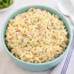 A bowl of creamy Classic Macaroni Salad on a picnic table.