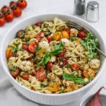 A bowl of Delicious Bruschetta Pasta Salad with tomatoes and basil.