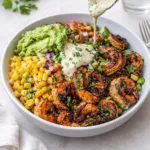A vibrant Grilled Shrimp Bowl with Avocado with corn salsa and creamy sauce