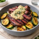 A colorful Grilled Steak Bowl with Sauce and Grilled Zucchini Bliss topped with creamy herb dressing.