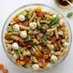 Layered Grilled Chicken Caprese Pasta Salad in a glass bowl