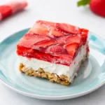 A delicious slice of Strawberry Pretzel Salad showing the three distinct layers on a white plate.