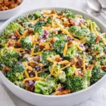 The Best Broccoli Salad in a white bowl on a wooden table