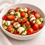 A vibrant Best Caprese Salad Bowl with cherry tomatoes and mozzarella pearls.