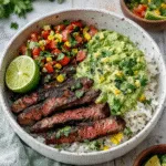 A colorful Cilantro Lime Steak Bowl with grilled steak, corn salsa, and avocado.