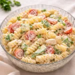 A vibrant bowl of Creamy Pasta Salad Bliss on a rustic table.