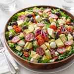 Fresh Italian Chopped Salad with mozzarella and salami in a wooden bowl