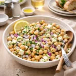 Lemony Chickpea Feta Salad in a wooden bowl on a sunny table