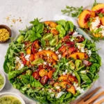 Summer Grilled Peach Salad in a white bowl on a wooden table
