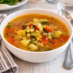 Fresh Summer Harvest Soup in a white bowl with basil
