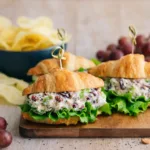 The BEST Chicken Salad in a white bowl with cranberries and pecans