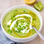 Creamy Zucchini Soup with Yogurt garnished with herbs and olive oil.